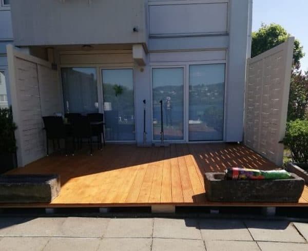 Holzterrasse mit Sichtschutzelementen und Sitzgruppe